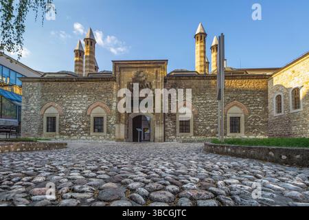Historisches Steingebäude in Sarajevo der Gazi Husrev-Beg Moschee mit markantem Minarett vor einem klaren blauen Himmel am späten Nachmittag Stockfoto