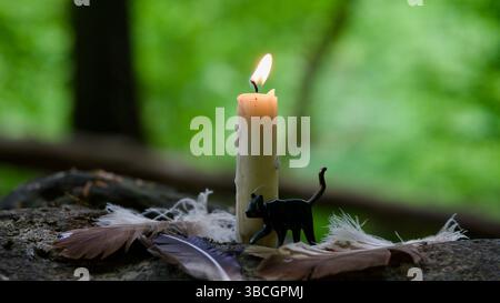 Kerzen mit Federn auf den Felsen eines Bergbaches. Stockfoto