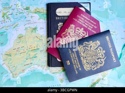 Drei britische Pässe mit zwei abgelaufenen EU-Pässen Europäischer Pass und aktuellem biometrischen Reisepass des Vereinigten Königreichs auf einer atlas-Seite von Australasien Stockfoto