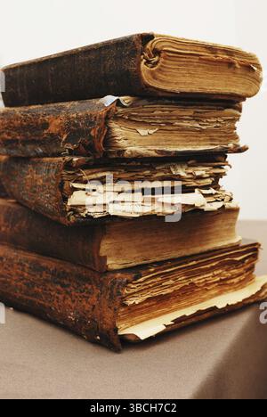 Ein Stapel alter zerrissener Bücher auf dem Tisch Stockfoto