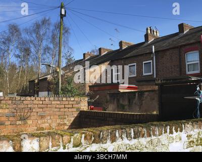 Blick auf eine Hintergasse von einem Hof mit Ziegelmauern in einer typischen alten englischen Arbeiterstraße Stockfoto