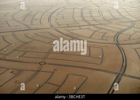 Aus der Vogelperspektive des Wüstenlandes, das in markierte Grundstücke mit sich kreuzenden Straßen unterteilt ist. Abu Dhabi, VAE Stockfoto