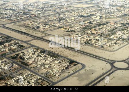 Luftaufnahme eines weitläufigen Wohnviertels in einer Wüstenregion mit breiten Straßen und Kreisverkehr. Abu Dhabi, VAE Stockfoto