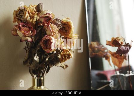 Strauß getrockneter Rosen in goldener Vase Stockfoto