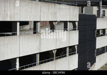 Dieses Bild zeigt eine Außenansicht eines mehrstöckigen Parkhauses. Die Betonkonstruktion zeigt das raue, industrielle Design, das typisch für den urbanen Bogen ist Stockfoto