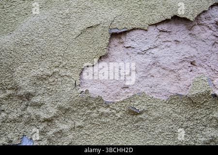 Alte verwitterte Ziegelwand mit gerissenem Putz und abblätternder Oberfläche Alte verwitterte Ziegelwand mit gerissenem Putz und abblätternder Oberfläche Stockfoto