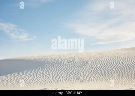Weiße Sanddünen mit weitläufigen Wolkenmustern am klaren blauen Himmel. Roadtrip USA Stockfoto