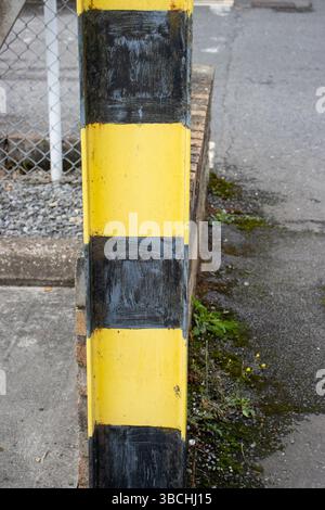 Gelb-schwarz lackierter Warnposten an einem Eingang Stockfoto