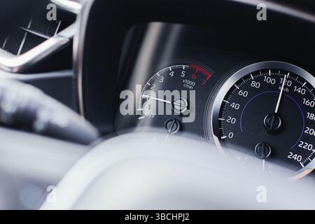 Modernes Auto-Armaturenbrett-Nahaufnahme. Drehzahlmesser und Tachometer. Instrumentenbrett des Fahrzeugs. U/MIN- und Drehzahlanzeigen. Innenansicht des Fahrzeugs. Fahrtechnik. Stockfoto