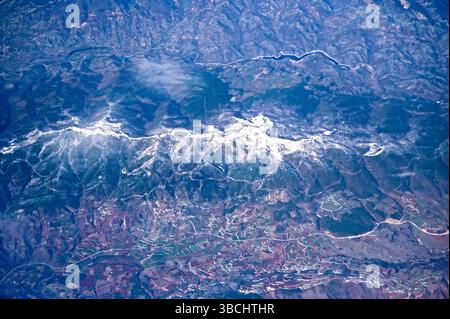 Aus der Vogelperspektive auf schneebedeckte Berge, Fluss und Landschaft mit Feld, Dorf und Straße über die türkische Landschaft. Stockfoto