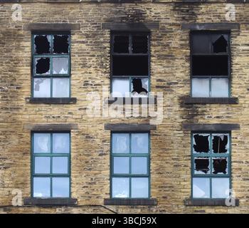 Kaputte Fenster in einem großen, ausgebrannten Industriehaus nach einem Brand Stockfoto