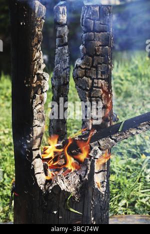 Der schwelende Baumstamm brannte in der Mitte aus Stockfoto