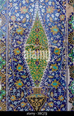 Eine Nahaufnahme von leuchtend blauen und grünen Blumenmosaikfliesen unterstreicht die detailreiche dekorative Arbeit im Sherdor Madrasa in Samarkand, Usbekistan. Stockfoto