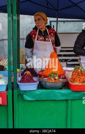Ein Verkäufer arrangiert an einem Verkaufsstand im Siab Basar, dem lebhaften lokalen Markt von Samarkand, Usbekistan Stockfoto