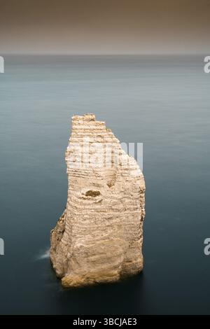 Eine vertikale Ansicht von einem Felsen Nadel Granit Felsen in einer ruhigen Dark Blue Ocean Stockfoto