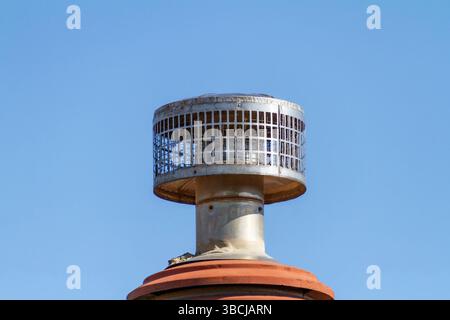 Ein Funkenfänger aus silbernem Edelstahl-Schornsteinkappe an einem Wohnhaus Stockfoto