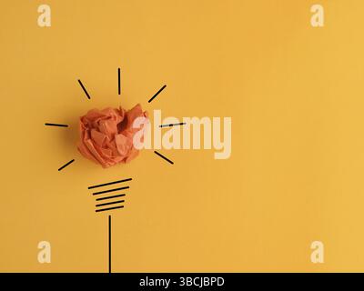 Zerknitterte Papierkugel als Glühbirne, konzeptuelles Geschäftsbild für neue Ideen oder Kreativität, gelber Hintergrund Stockfoto
