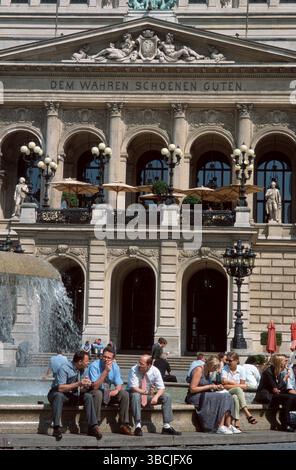 Menschen, die am Brunnen sitzen, Frankfurt, Hessen, Leute, die Mittagspause am Brunnen vor der Alten Oper machen, Frankfurt am Main, Porträt, Freizeit, Leisu Stockfoto