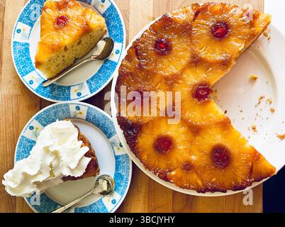 Hausgemachter Ananaskuchen mit kandierten Kirschen auf hölzernem Hintergrund. Direkt darüber. Stockfoto