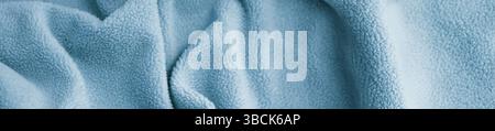 Hellblaue fließende Textiloberfläche. Sanfte Wellen in hellem Gewebe Stockfoto