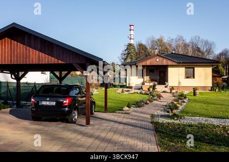 PETRVALD, TSCHECHISCHE REPUBLIK - 16. NOVEMBER 2018: Ein neu erbautes Familienhaus mit einer Holzgarage und einem schwarzen Skoda Fabia-Auto. Ein typischer Vorort in der Nähe von Big Cit Stockfoto
