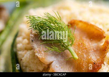 In Nahaufnahme ziert ein Dill-Zweig eine Beilage aus Couscous und Gemüse. Ausgewählter Fokus. Hochwertige Fotos Stockfoto