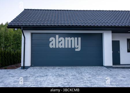 Moderne Garagenhöhe. Designer Einfahrt Garage mit Haus. Modernes Design. Luxuriöses Äußeres. Hubtor. Segmentale Garage. Stockfoto