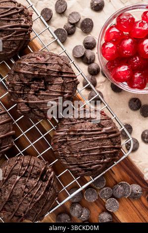 Triple Chocolate Cherry Plätzchen mit Chocolate Chips und kandierten Kirschen: Chocolate Chips Plätzchen mit dunkler Schokolade auf Draht Kühlregal Stockfoto
