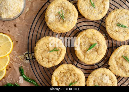 Rosmarin-Lemon Sugar Plätzchen auf Round Wire Cooling Rack: Ober-Nahaufnahme von frisch gebackenen selbstgemachten Zuckerkeksen, die auf einem Drahtrad abkühlen Stockfoto
