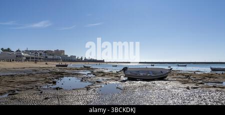 Cadiz, Spanien - 16. Januar 2021: Blick auf den Strand von La Caleta in Cadiz mit hölzernen Fischerbooten, die bei Ebbe gestrandet sind Stockfoto