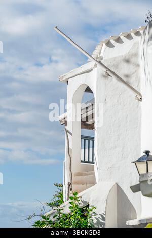 Weiße Mediterrane Architektur Mit Elegantem Balkon In Binibeca Vell, Traditionelles Menorquinisches Fischerdorf Design, Weiß Getünchte Gebäude Gegen Blu Stockfoto