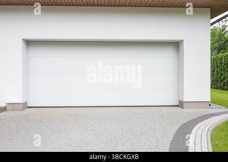 Moderne Garagenhöhe. Designer Einfahrt Garage mit Haus. Modernes Design. Luxuriöses Äußeres. Hubtor. Segmentale Garage. Stockfoto