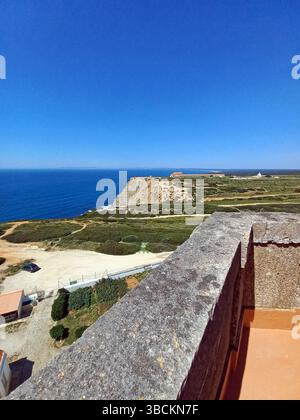 Atemberaubende Aussicht vom Leuchtturm Cape Espichel in Sesimbra Portugal aus mit dramatischen Klippen, üppigem Gelände und traditionellem Architekten am Meer Stockfoto