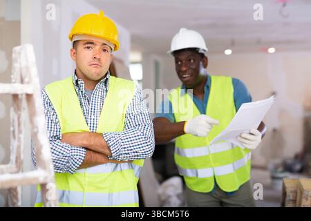 Porträt eines verwirrten Baumeisters und wütenden Baumeisters auf der Baustelle Stockfoto