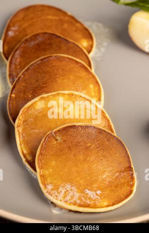 Schmelzende Butter auf heißen frisch gebackenen Pfannkuchen, mehrere Pfannkuchen aus Milch mit Mehl, auf dem Butter schmilzt, Nahaufnahme Stockfoto
