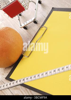 Notizblock mit gelbem Papier und einem Einkaufswagen Stockfoto