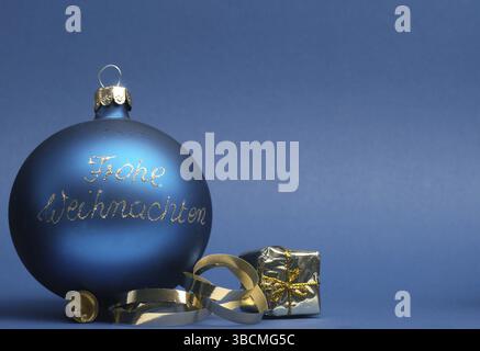 Blaue vintage Weihnachtsbaummit den deutschen Worten Frohe Weihnachten auf blauem Hintergrund mit Platz für Ihren Text oder Ihr Bild, saisonales Urlaubskonzept Stockfoto