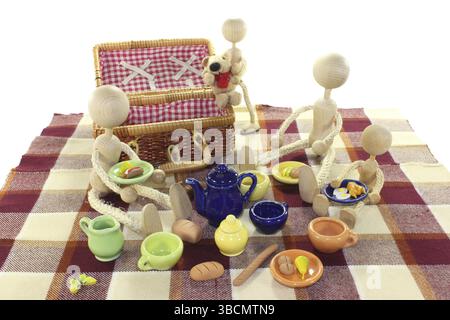 Picknick mit Familie, Korb, Decke und Geschirr auf hellem Hintergrund Stockfoto