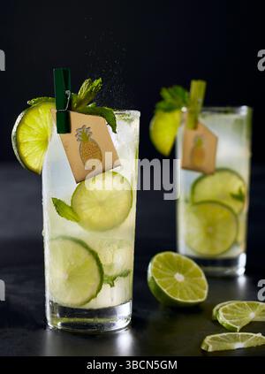 Limettencocktails mit Minze- und Ananasanhänger auf dunklem Hintergrund Stockfoto