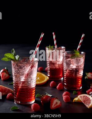 Beerencocktails mit Strohhalmen, Zitrusscheiben und Minzgarnitur Stockfoto