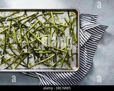 Gerösteter Spargel auf Metalltablett mit gestreiftem Handtuch darunter Stockfoto