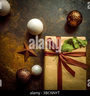 Nahaufnahme eines wunderschön gewickelten Geschenkpakets mit braunem Papier außen und einem reichen Band, das in einer Schleife gebunden ist. Stockfoto