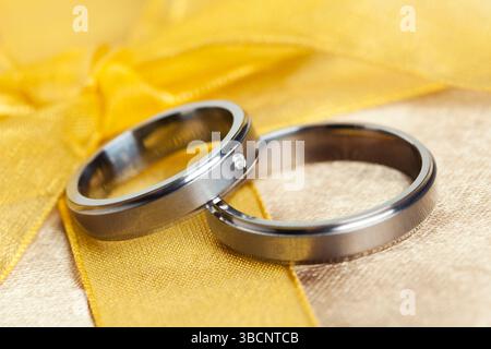 Paar Trauringe auf goldenen Bogen Stockfoto