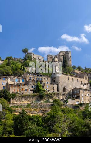 Das hoch gelegene Dorf Montbrun les Bains mit seinen mittelalterlichen Burgruinen unter einem blauen Sommerhimmel in Drome Provencale, Auvergne Rhone Alpes Region, Fra Stockfoto