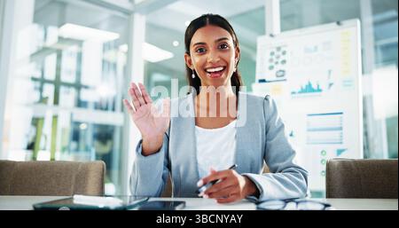 Porträt, Geschäftsfrau und Wwinken in Videoanruf, um finanzielle Informationen über Analysen im Büro zu erhalten. Lächeln, Mitarbeiter und Begrüßung in virtuellen Meetings im Internet Stockfoto