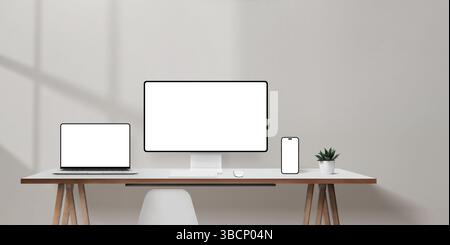 Heller Bürotisch mit Laptop, Computermonitor und Smartphone-Mockups, leere Wandfläche für Werbetexte Stockfoto