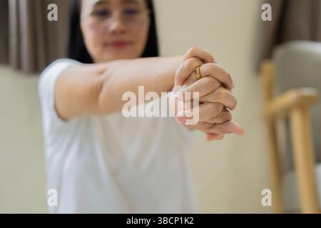 Gesundes Lifestyle-Konzept. Attraktive Erwachsene asiatische Frau, die zu Hause Yoga macht und Yoga dehnt. Achtsames Meditationskonzept. Wohlbefinden. Stockfoto