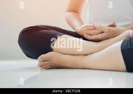 Yoga-Achtsamkeitsmeditation. Abgeschnittene Aufnahme einer älteren erwachsenen Frau, die zu Hause Yoga praktiziert. Stockfoto