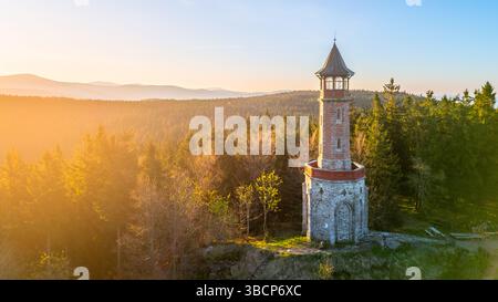 Der Stepanka Aussichtsturm erhebt sich im frühen Morgenlicht, umgeben von lebhaftem Grün in Korenov, Isergebirge. Eine ruhige Atmosphäre lädt Besucher ein, diesen malerischen Aussichtspunkt zu erkunden. Stockfoto
