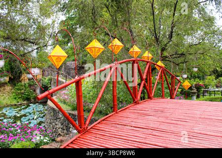 Vietnam, Hue. Hue Imperial City (Hoàng Thành Hu). Ein Blick auf die üppigen Gärten der kaiserlichen Zitadelle mit einer Holzbrücke. Stockfoto